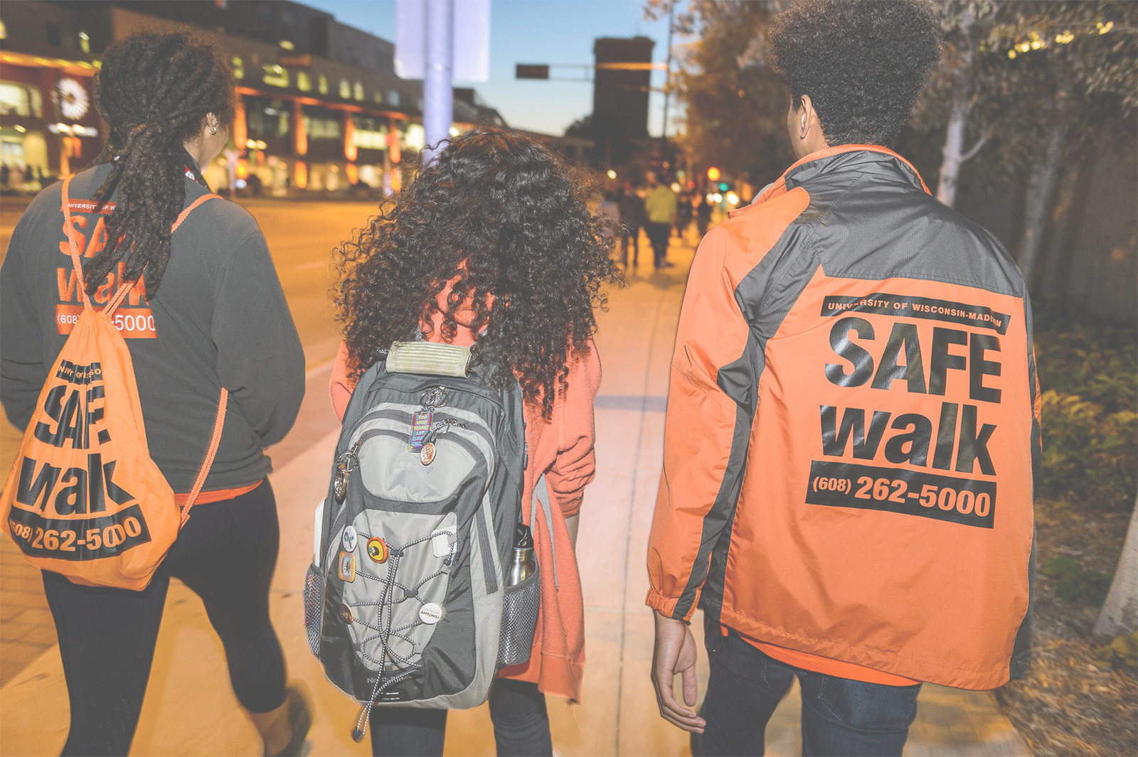 Two students in SAFEWalk gear provide safe escort to another student.