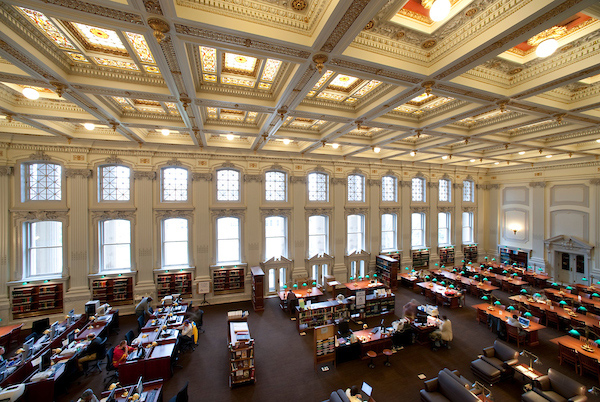 Rows of study tables are dwarfed by high ceilings and grand windows in this reading room and library.