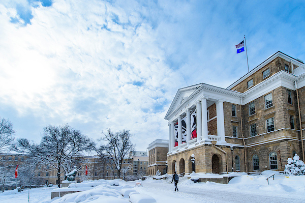 Snow covers the ground and some walkways in front of Bascom Hall.