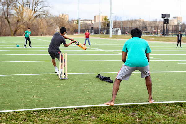 Students playing cricket.