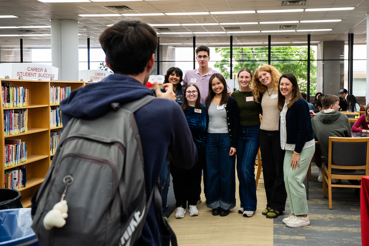 A group of people pose for a photo in a library setting.